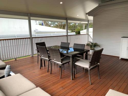 a patio with a table and chairs on a deck at Fully Renovated 3 Bedroom House in Belmont