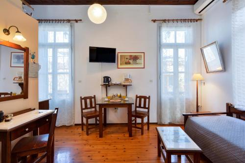 Una sala de estar con una cama, una mesa y sillas. en Silde Studios & Apartments, en La Canea