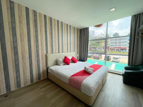 Un dormitorio con una cama con almohadas rojas y una ventana en City Kuchai Hotel -Kuchai Lama,Kuala Lumpur, en Kuala Lumpur