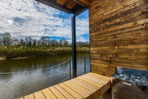 a house on the water with a wooden deck at no. 1 in Kulpin