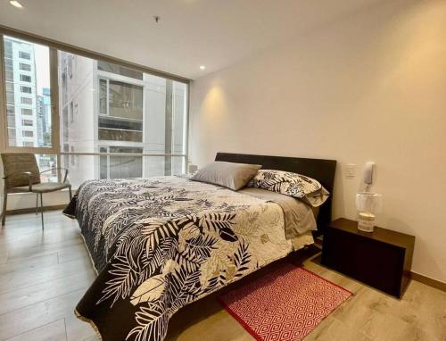 - une chambre avec un lit et une grande fenêtre dans l'établissement SPECTACULAR SUITE, à Quito