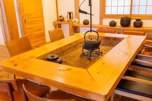 una mesa de madera con una olla encima en 響きの宿, en Sato-moriya