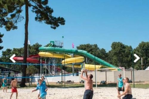 Un groupe de gens jouant à un jeu dans un parc dans l'établissement Mobilhome 4 pers La palmyre, aux Mathes