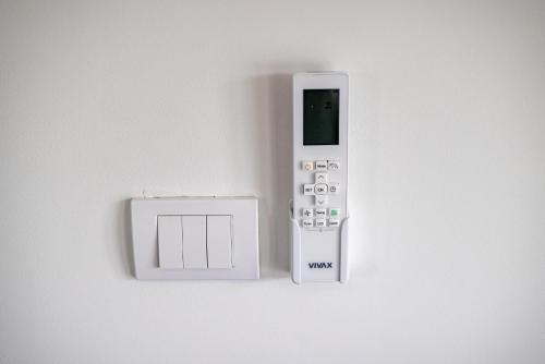 a remote control next to a lightswitch on a wall at no. 1 in Kulpin