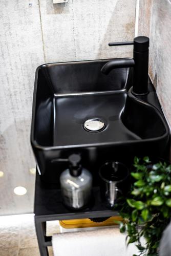 a black sink with a soap dispenser in a bathroom at no. 1 in Kulpin
