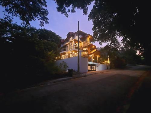 a large house with lights on it at night at El Castillo Bed and Breakfast in Angono