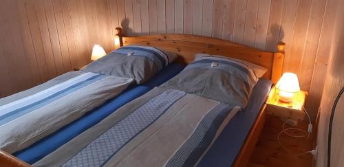 2 Einzelbetten in einem Zimmer mit 2 Lampen in der Unterkunft Ferienhaus Diedrichsen in Brekendorf
