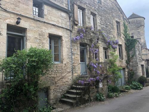 a building with purple flowers on the side of it at Le Clos de Melanie in Flavigny-sur-Ozerain