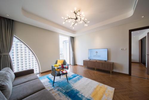 a living room with a couch and a tv at Grand Tourane Nha Trang Hotel in Nha Trang