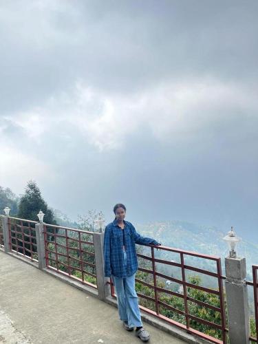 a man standing next to a fence at Delohighs in Kalimpong