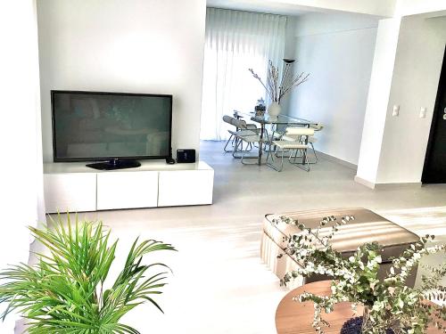a living room with a large flat screen tv at Grand Panoramic Villa II Lagonissi in Lagonissi