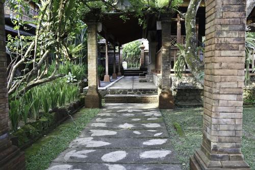 a stone walkway leading to a house with a porch at Murni's Houses & Spa in Ubud