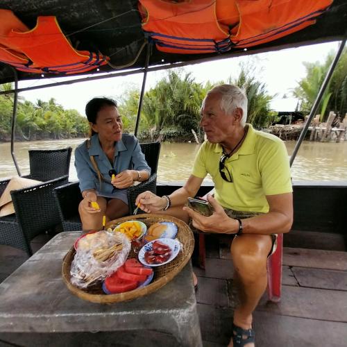 a man and a woman sitting at a table with food at BenTrestay in Giồng Tú Ðiền