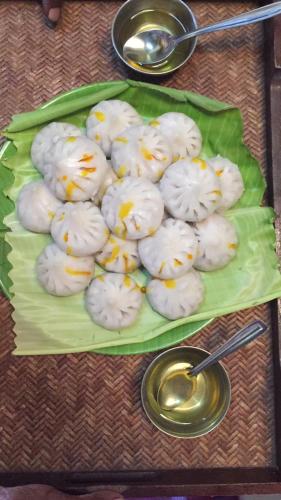 a plate of white cookies with yellow sprinkles on a table at Windchime Cottages in Alibaug