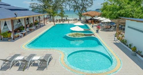 a swimming pool with chairs and umbrellas next to the beach at Sara Resort in Koh Rong Sanloem