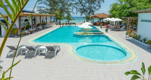 - une piscine avec des chaises et des parasols à côté de l'océan dans l'établissement Sara Resort, à Koh Rong Sanloem