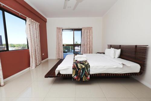 a bedroom with a large bed and a large window at Gardenia Apartment-04 in Nadi