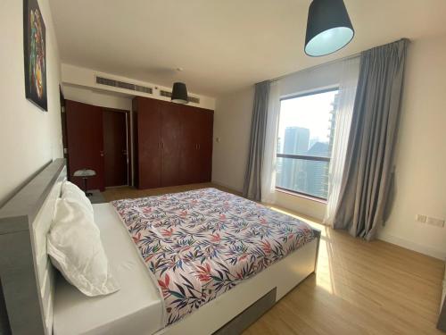 a bedroom with a bed and a large window at Al Mashreq 2 BR Rimal 1, City View - JBR in Dubai
