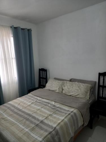 ein Schlafzimmer mit einem Bett mit einer Decke und einem Fenster in der Unterkunft Casa amueblada a unos minutos del aeropuerto in Veracruz
