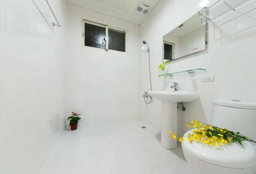 a white bathroom with a toilet and a sink at Free World B&B in Wujie