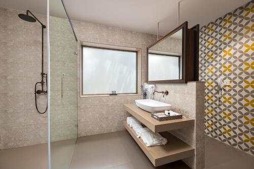 a bathroom with a sink and a shower at The Yellow House, Goa - IHCL SeleQtions in Anjuna