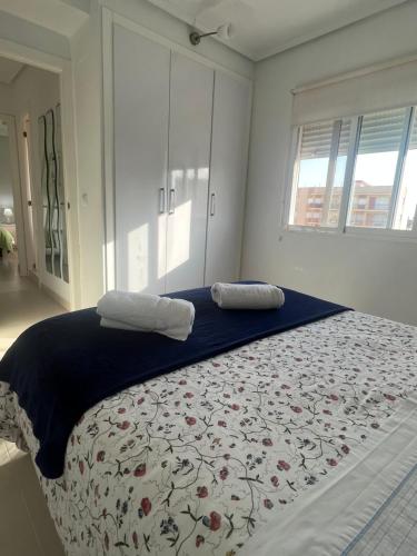 um quarto com uma cama grande com duas almofadas em Apartamento junto a playa y cerca de campo de golf em El Perellonet