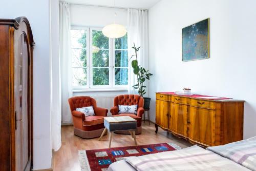 1 dormitorio con 1 cama, 2 sillas y vestidor en Schön wohnen nähe Schönbrunn, en Viena