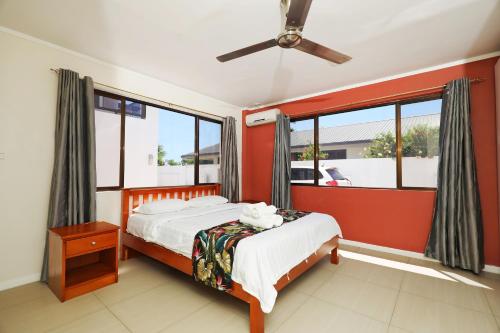 a bedroom with a bed and a large window at Gardenia Apartment-02 in Nadi