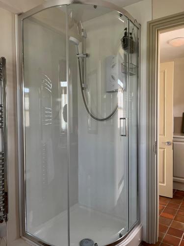 a shower with a glass door in a bathroom at The Old School, Idbury, OX7 6RU in Chipping Norton