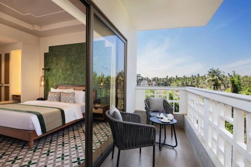a bedroom with a bed and a balcony at The Yellow House, Goa - IHCL SeleQtions in Anjuna