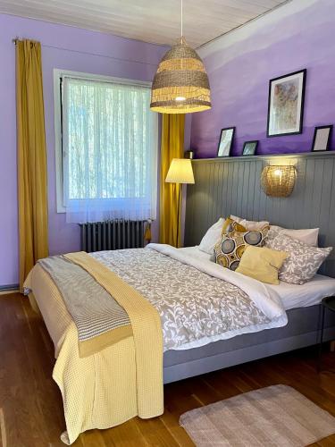 a bedroom with purple walls and a large bed at Na samotě U Včelína in Lančov