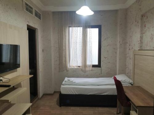 niewielka sypialnia z łóżkiem i oknem w obiekcie Hotel My Rose w mieście Batumi