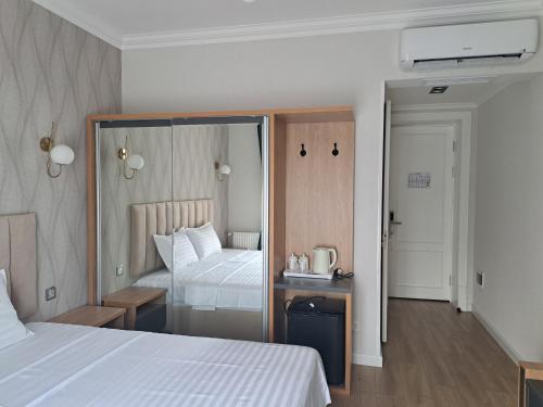 a hotel room with a bed and a mirror at WELLFORT HOTEL in Samarkand