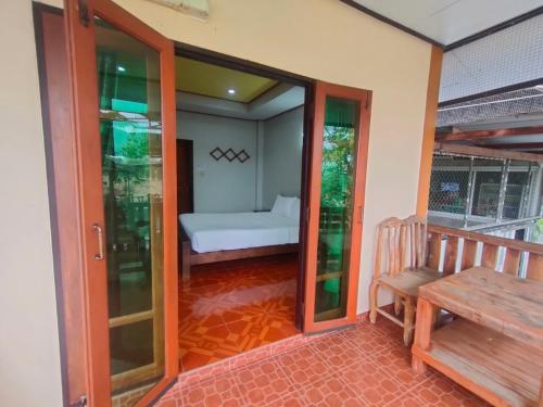 a room with a porch with a bench and a bed at Chatchawan Resort in Ban Tha Sao