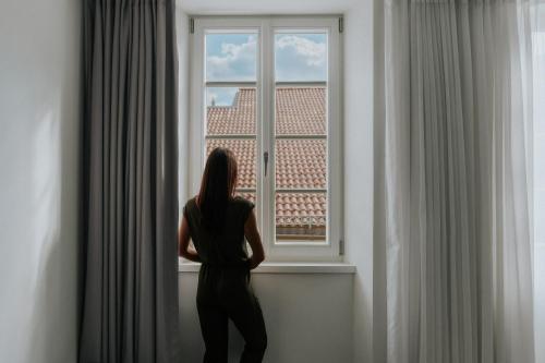 a woman standing in front of a window at Guesthouse Suiteseven in Merano