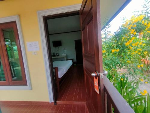 a door leading to a room with a bed and a balcony at Chatchawan Resort in Ban Tha Sao