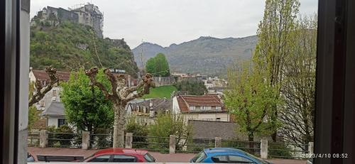 vistas a una ciudad con edificios y montañas en Appartements touristique - La Colombière en Lourdes