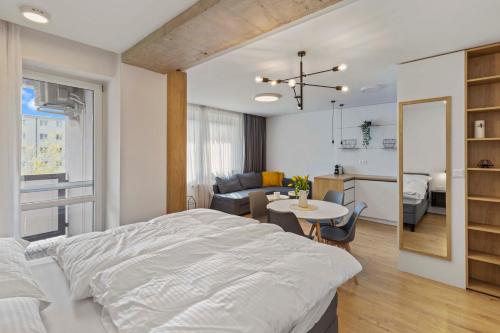 a bedroom with a bed and a living room at LAM Concrete w AC & Balcony in Bratislava