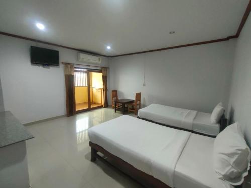 a hotel room with two beds and a television at Chatchawan Resort in Ban Tha Sao