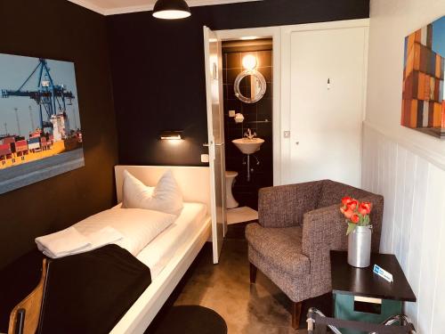 a room with a couch and a chair and a table at City Hostel by beans parc in Wilhelmshaven
