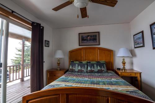 a bedroom with a bed and a balcony at Front Room Lynnview Lodge in Haines