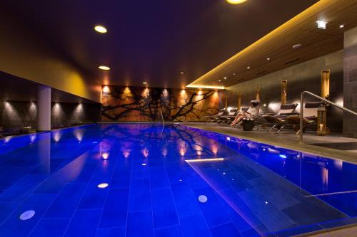 a swimming pool at night with blue lighting at Almhotel Hochhäderich in Riefensberg