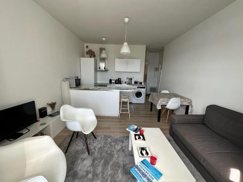 a living room with a couch and a kitchen at Appartement Design III - Port du Rosmeur - Douarnenez in Douarnenez