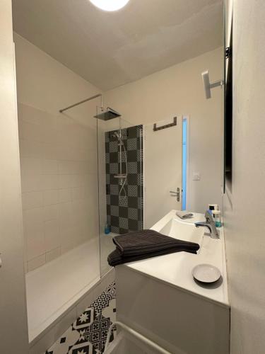 y baño blanco con lavabo y ducha. en Appartement Design III - Port du Rosmeur - Douarnenez, en Douarnenez