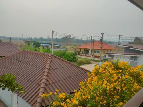 a view of roofs of houses with yellow flowers at Chatchawan Resort in Ban Tha Sao