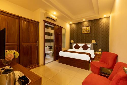 Habitación de hotel con cama y silla roja en Airport Saigon Hotel - Gần ẩm thực đêm chợ Phạm Văn Hai, en Ho Chi Minh