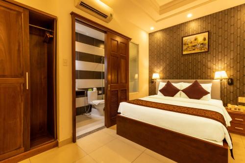a hotel room with a bed and a bathroom at Airport Saigon Hotel - Gần ẩm thực đêm chợ Phạm Văn Hai in Ho Chi Minh City