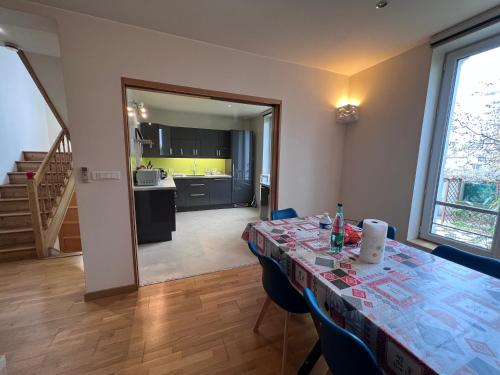 une salle à manger avec une table et une cuisine dans l'établissement Maison Climatisée 04 chambres Paris Disney CDG, à Gagny