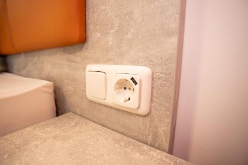 a white outlet on a wall next to a bed at Seehotel Forst in Forst