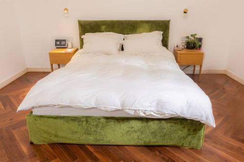 a large green bed with white sheets and pillows at Tel Aviv Center Seaside Villa with a Pool & Rooftop in Tel Aviv